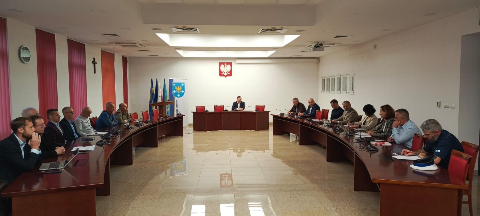 Sala narad i siedzące przy stołach osoby