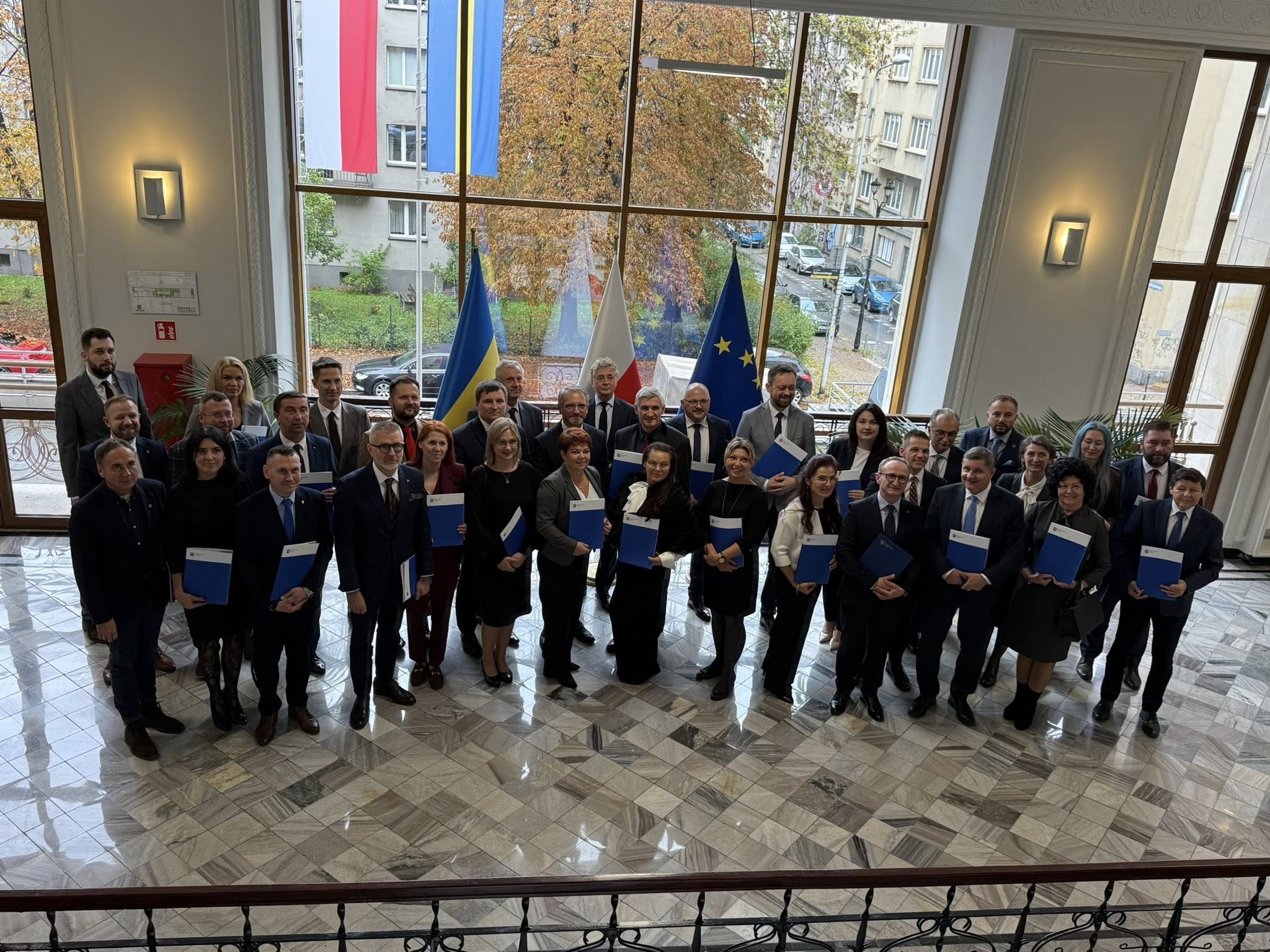 Osoby znajdujące się pomieszczeniu pozujące do zdjęcia robionego z ujęcia z góry 