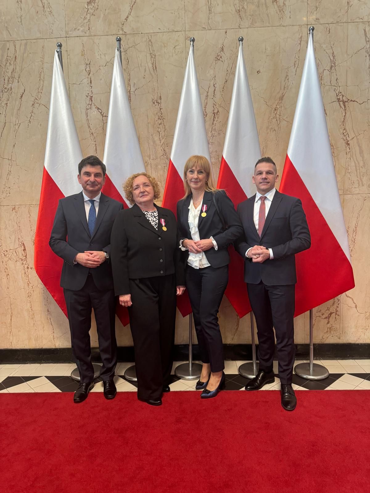 Zdjęcie pozujących do zdjęcia czterech osób 