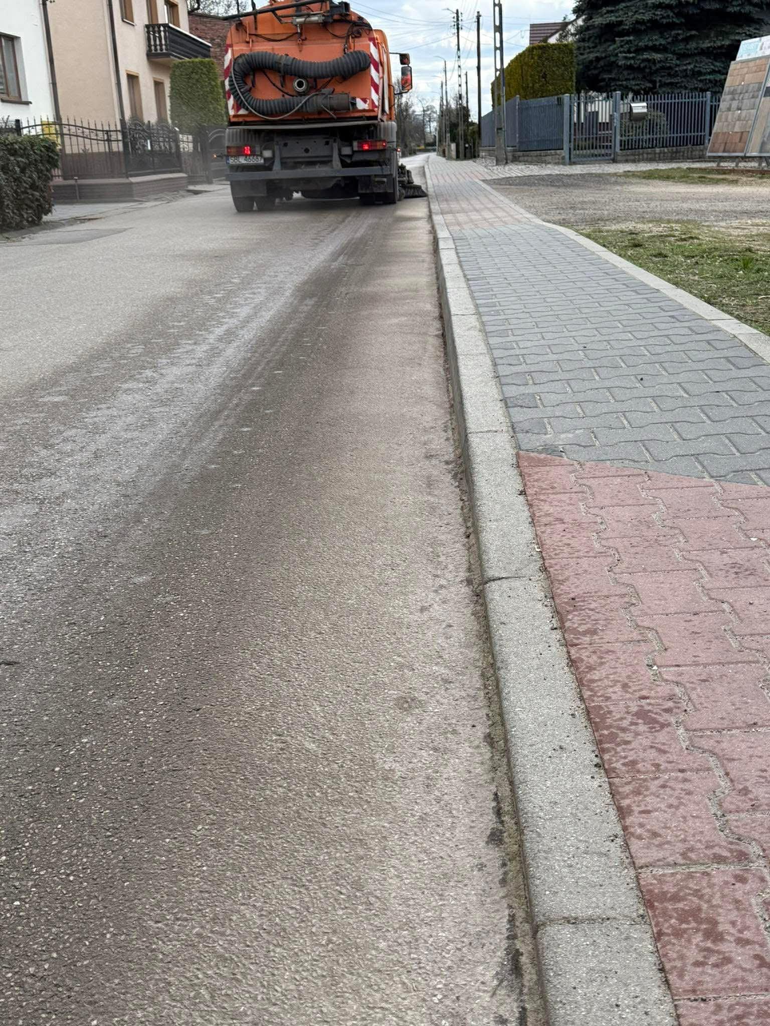 Posprzątany chodnik i droga. Samochód sprzątający drogi. 