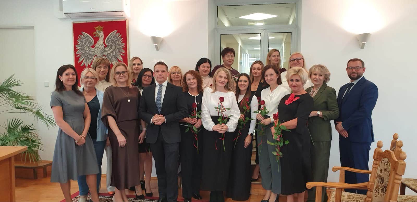 Kobiety i mężczyźni pozujący do zdjecia w pomieszczeniu 