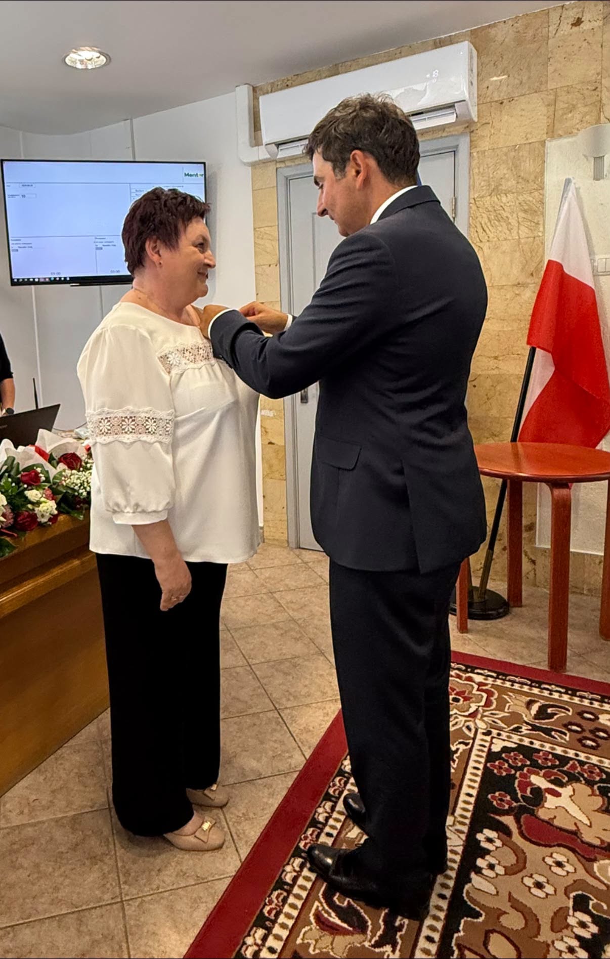 Mężczyzna wręczający medal kobiecie 